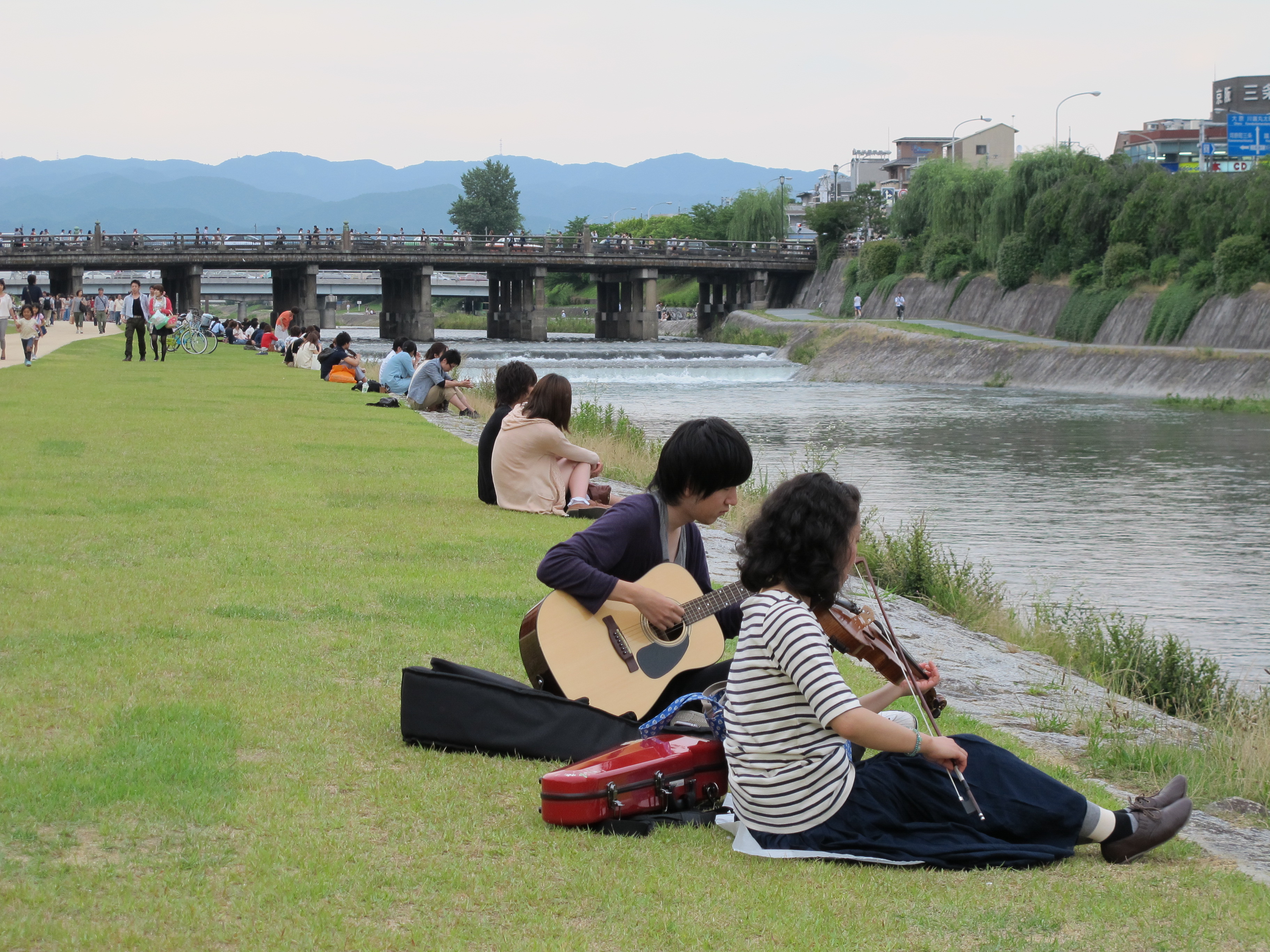 Couples sitting by the Kamo river in Kyoto