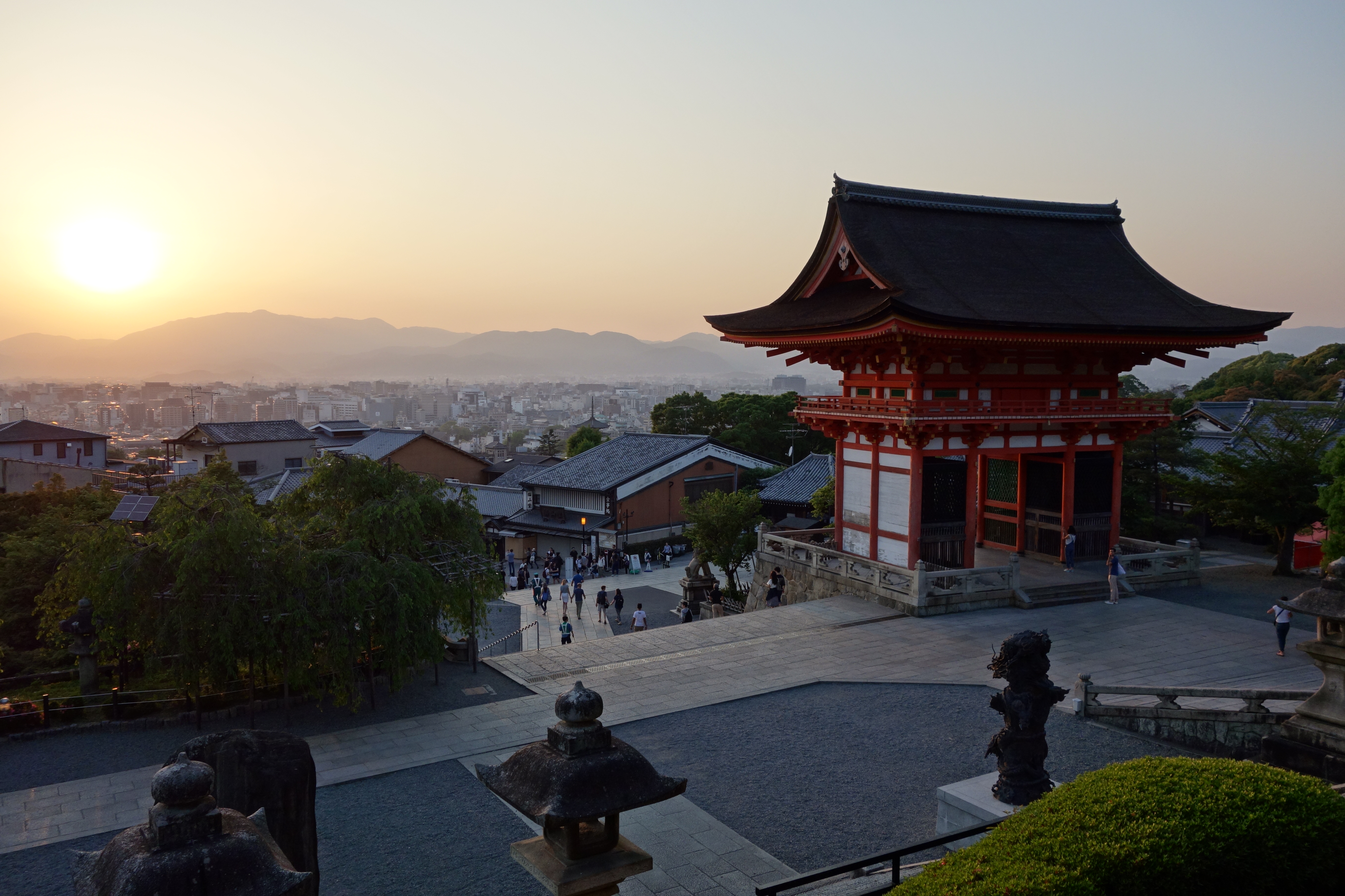 View of Kyoto and Niōmon from Kiyomizu-dera. The view is facing west and sunset is visible over Mount Atago.