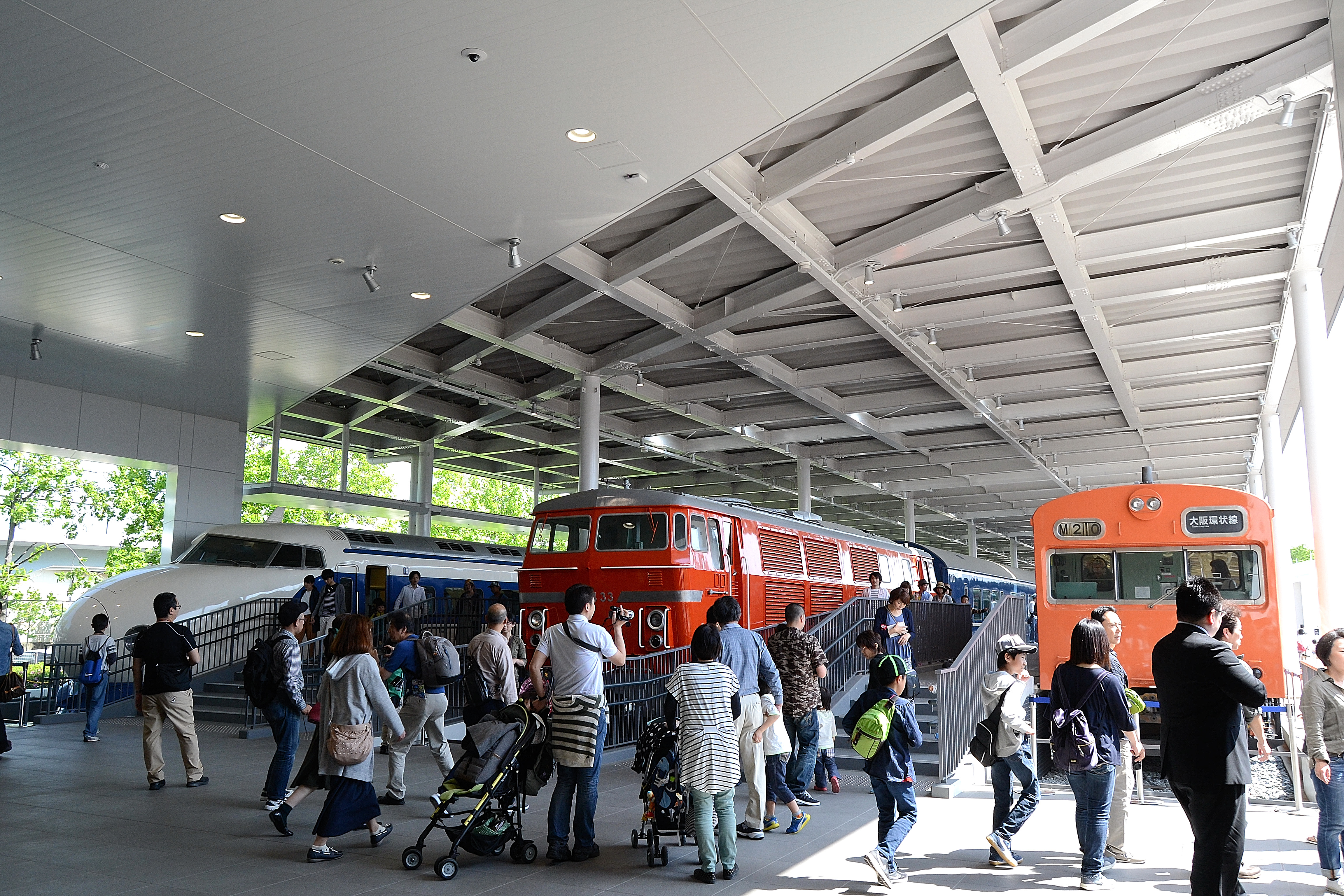 The Promenade exhibition area at Kyoto Railway Museum with 0 series shinkansen car 22-1, Class DD54 diesel locomotive DD54 33, and 103 series EMU car KuHa 103-1