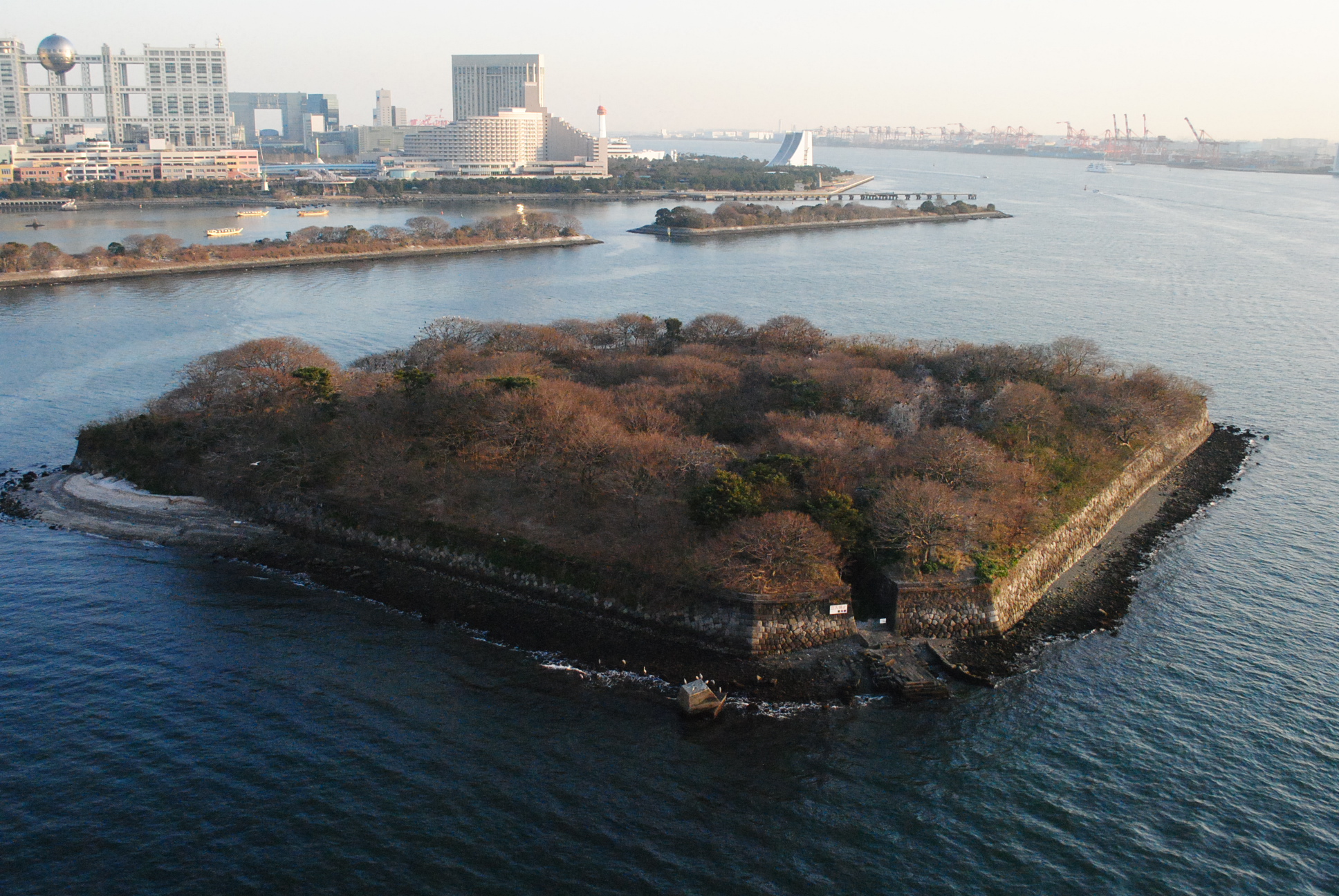Dai-Roku Daiba (第六台場) or "No. 6 Battery", one of the original Edo-era battery islands, as viewed from the Rainbow Bridge. The developed area of Odaiba is in the background.