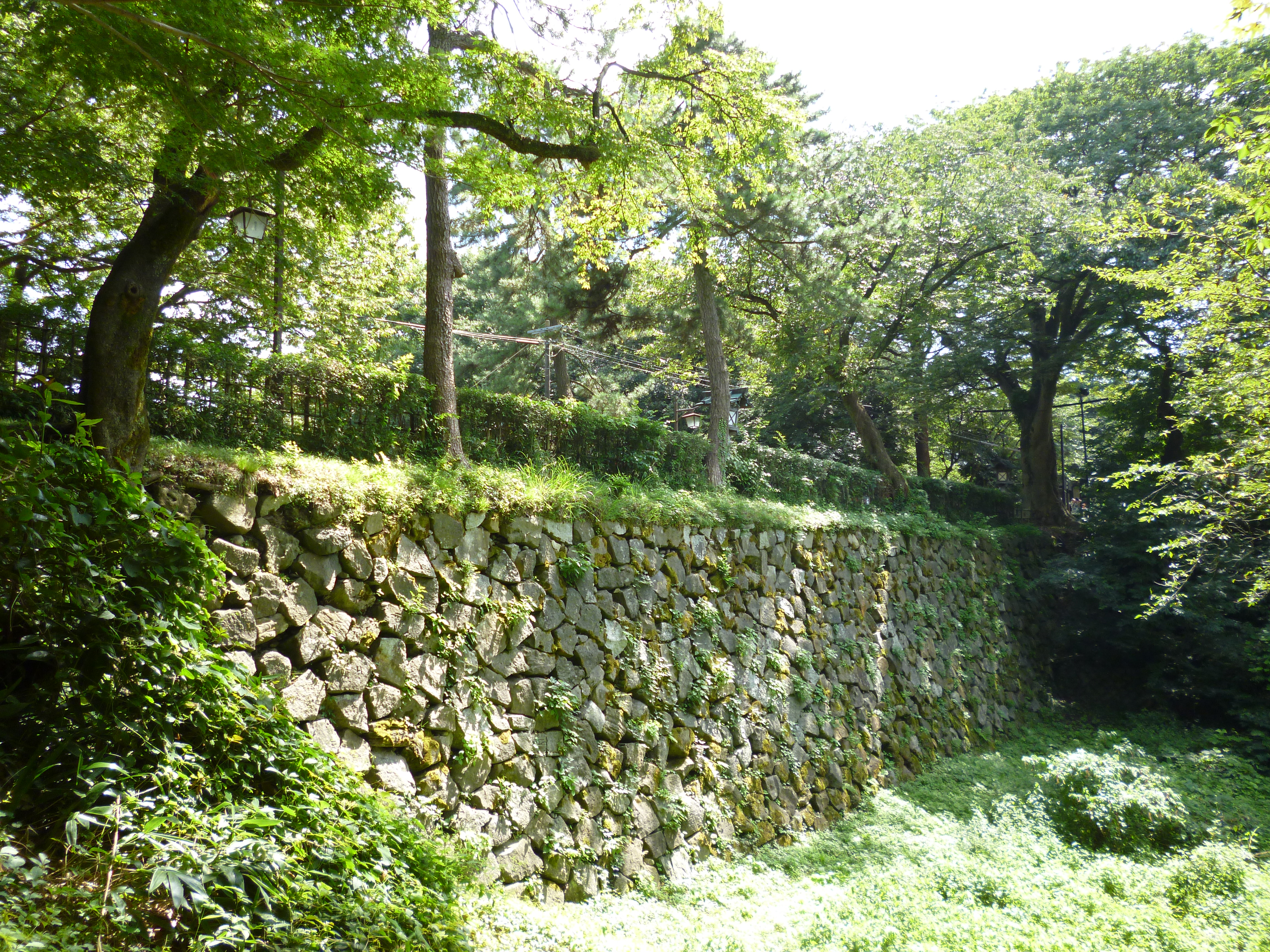 Stone wall and moat at the Takaoka Castle in Takaoka, Toyama Prefecture, Japan.