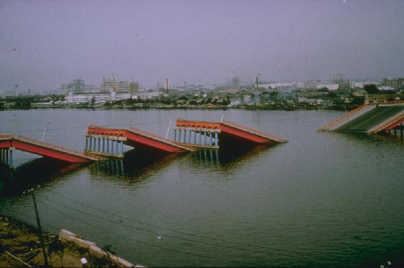 Picture of the Showa bridge in Niigata showing damage caused by the earthquake in 1964. Liquefaction led to collapse of two piers and the span between them. The free movement allowed at one end of each span caused the remaining spans to drop into the river