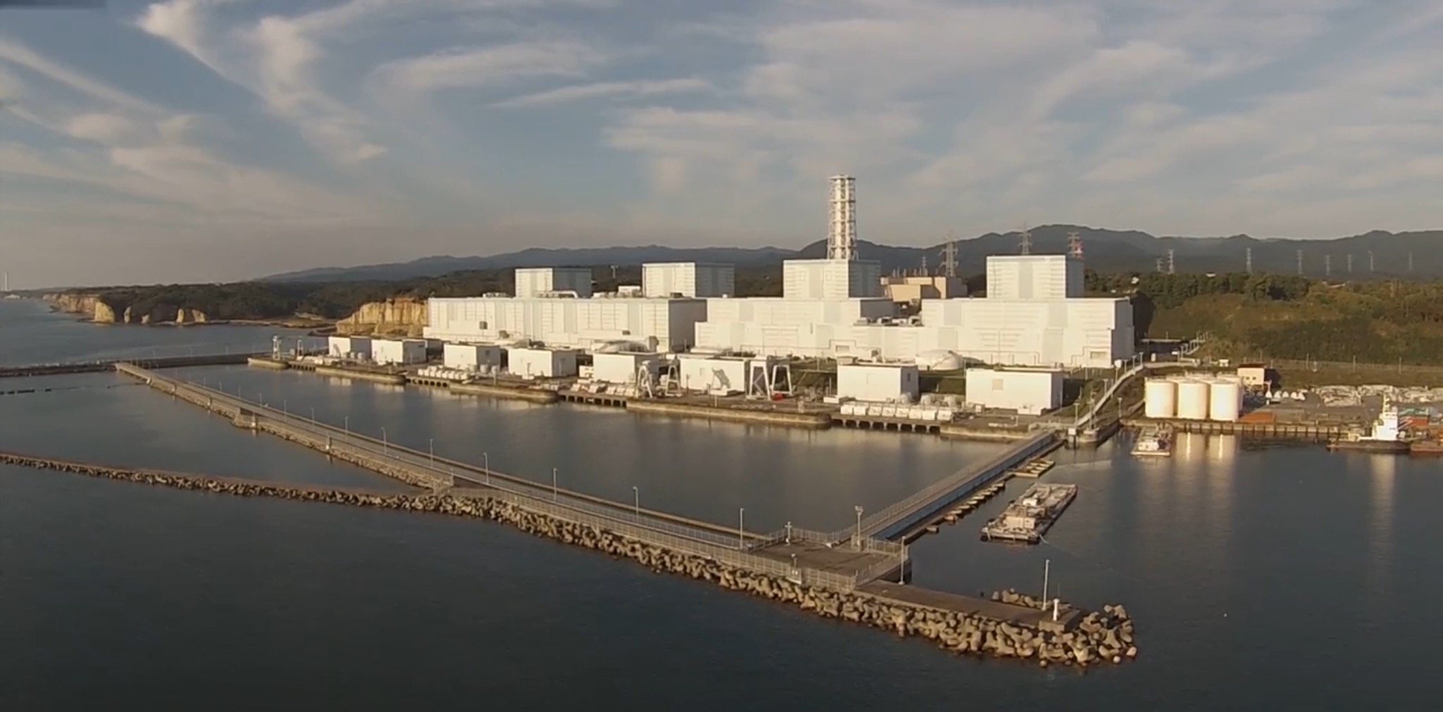 Still frame taken from aerial video of the Tepco 2F nuclear generating station showing its artificial harbor, turbine and reactor buildings. Source video was shot with a GoPro Hero3 carried by a 3DR Iris+ quadcopter.