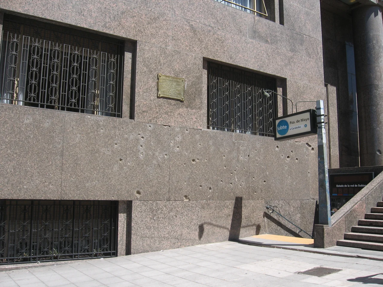 Orificios de bala calibre 20 mm y de esquirlas en los mármoles de la fachada del actual Ministerio de Hacienda y Finanzas Públicas de Argentina en Plaza de Mayo, producto del ametrallamiento aéreo en el gravísimo atentado terrorista por soldados juramentados a proteger vidas y bienes de la ciudadanía, el 16 de junio de 1955 durante el frustrado golpe de estado contra el presidente Juan Domingo Perón.