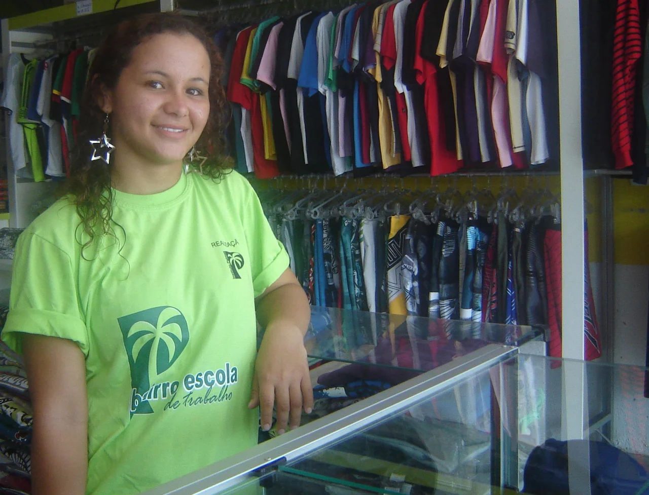 A Bairro Escola student gaining work experience in a neighborhood commercial shop.