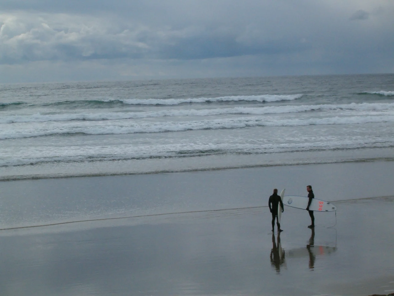 Surfers on the beach at Ucluelet, BC, Canada