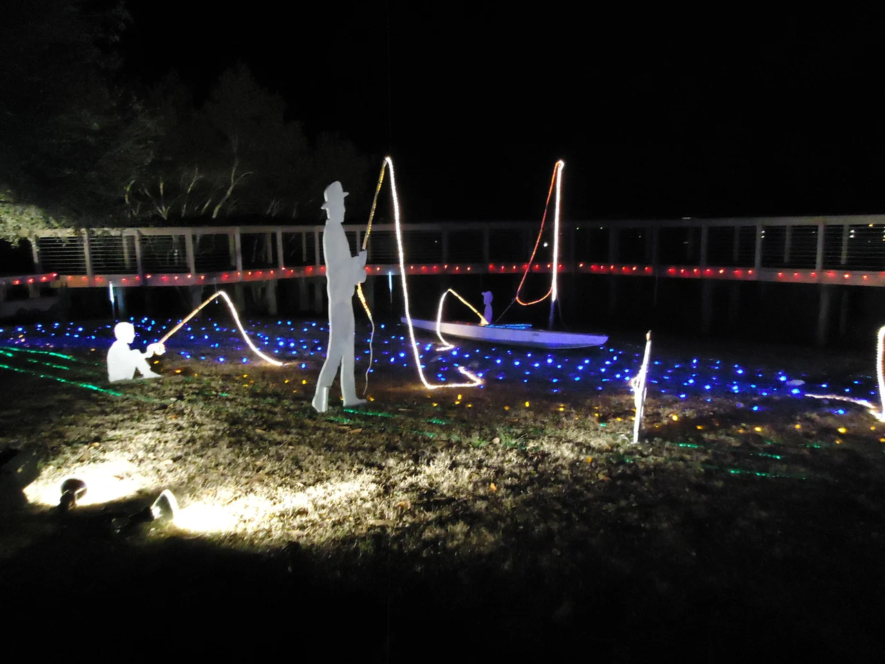 A Christmas lights scene of boats and fisherman at Enchanted Airlie Gardens (2014) in WIlmington, NC