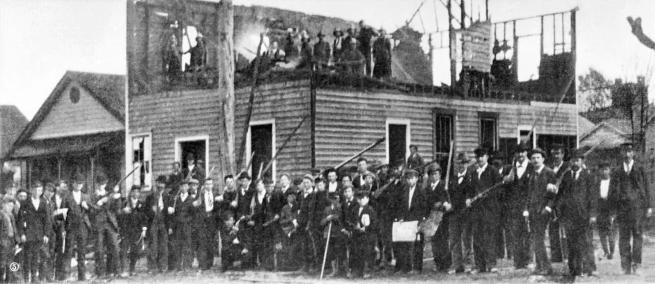 Wilmington, N.C. massacre, 1898: Armed militiamen in front of the burned-down "Record" press building.