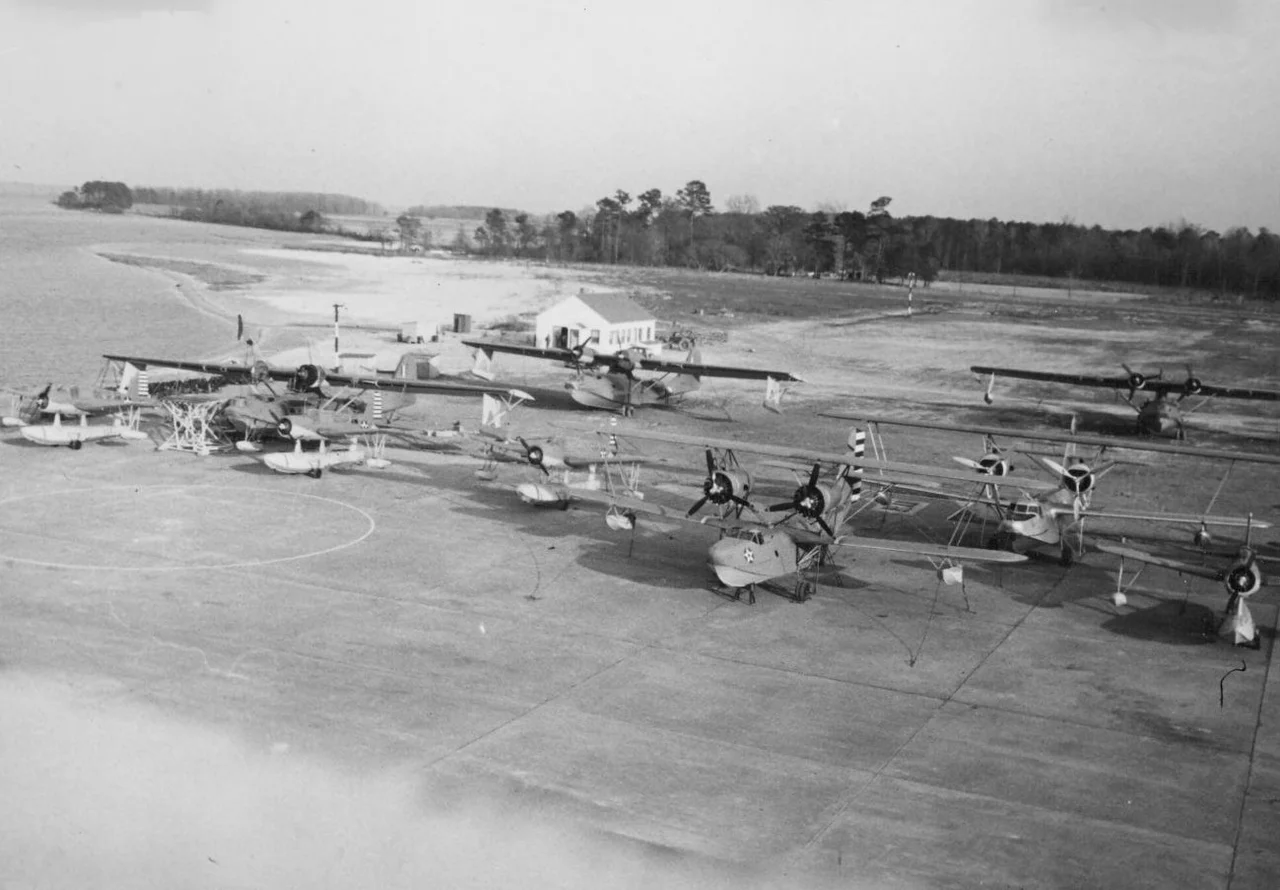 Four Vought OS2U Kingfishers, three Consolidated PBY Catalinas, and two Hall PH flying boats parked at the U.S. Coast Guard Air Station (CGAS) Elizabeth City, North Carolina (USA), 21 March 1942.