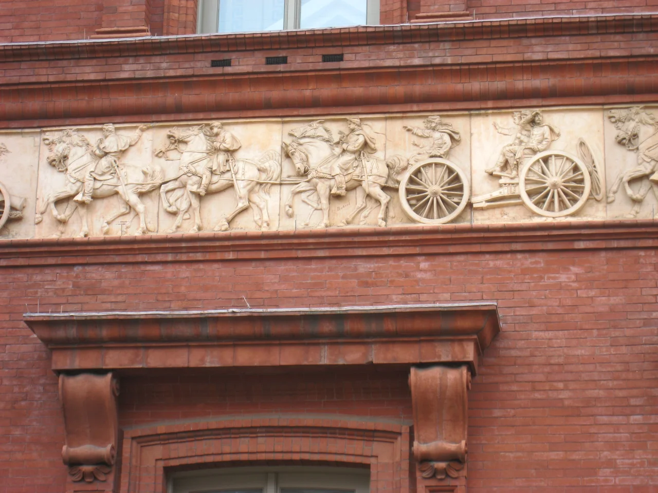 Frieze detail with artist Caspar Buberl's signature, National Building Museum (the former Pension Bureau building), Washington, DC, USA. This frieze was created in 1887 by Caspar Buberl (1834-1899). Because of the art's age, and the fact that the artist died more than 70 years ago, this image is no longer subject to any form of copyright restrictions.