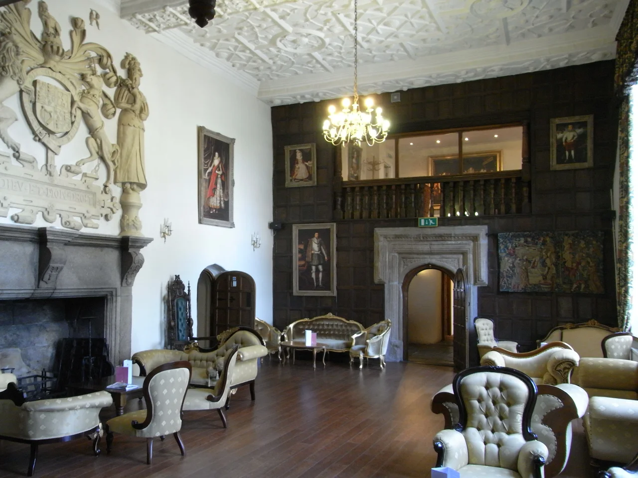 The Great Hall, Boringdon Hall, Plympton, Devon, looking eastwards
The stone doorway now in the centre of what would originally have been the screens passage was moved from the SW room of the house. The woodwork, floor and decorative plaster ceiling are all modern; the pictures are photographic reproductions. The Great Hall however retains its original grand proportions and is lit by two double-height windows on the south side