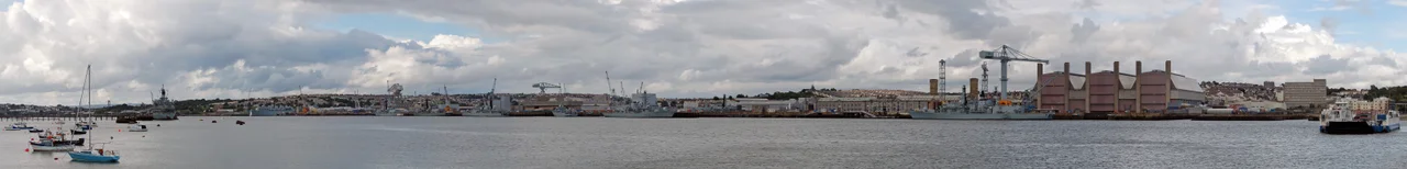 HMNB Devonport in Plymouth as seen from the Torpoint ferry. 10 naval vessels (5 of which are Type 23 frigates) are moored in the dockyard, and one of the other Torpoint ferries is also visible.