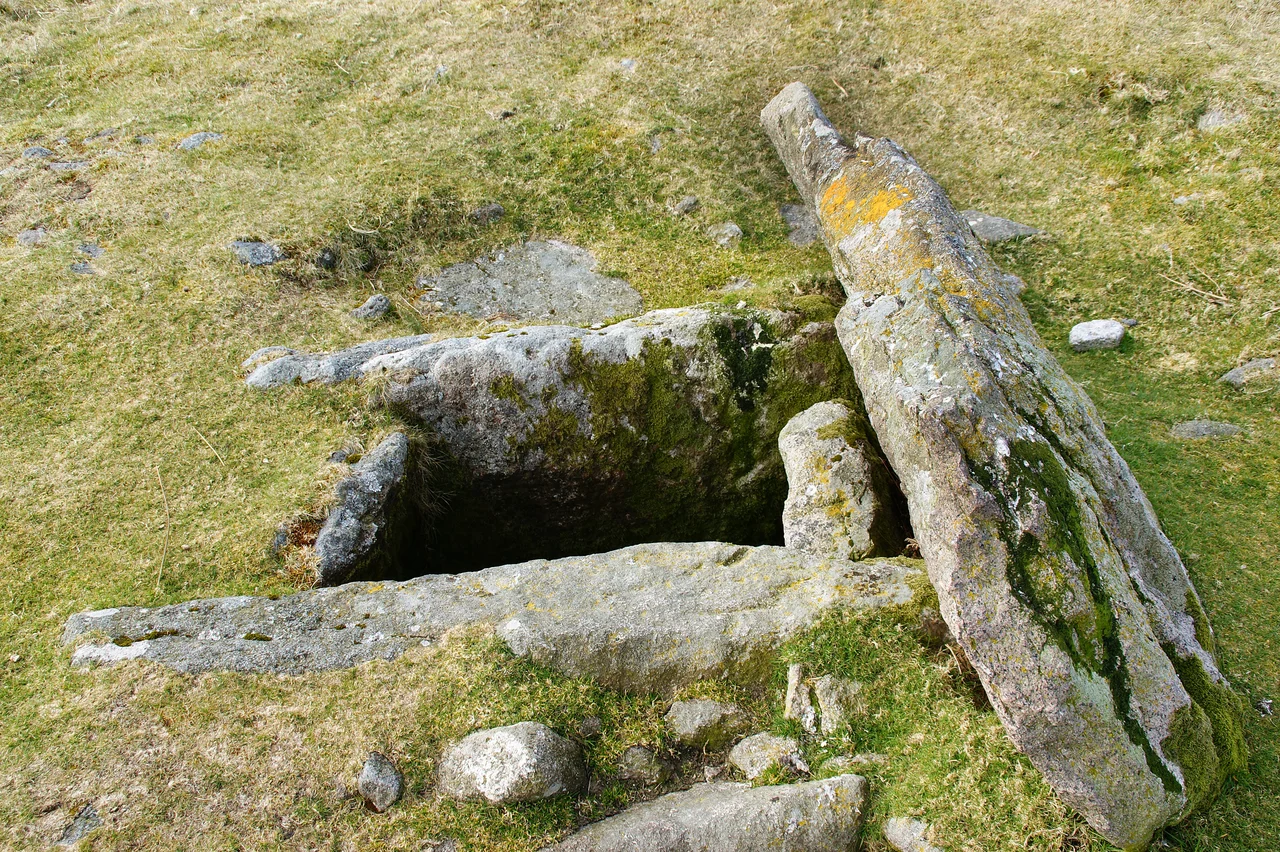 Kistvaen in Drizzlecombe on Dartmoor in South Devon, UK.  The cap stone can be clearly seen upended on the right of the image behind the box like structure of the cist.    For detail &amp; further images see File:Drizzlecombe kist 1.JPG, File:Drizzlecombe kist 2.JPG, File:Drizzlecombe kist 3.JPG, File:Drizzlecombe kist 4.JPG &amp; File:Drizzlecombe kist 6.JPG.