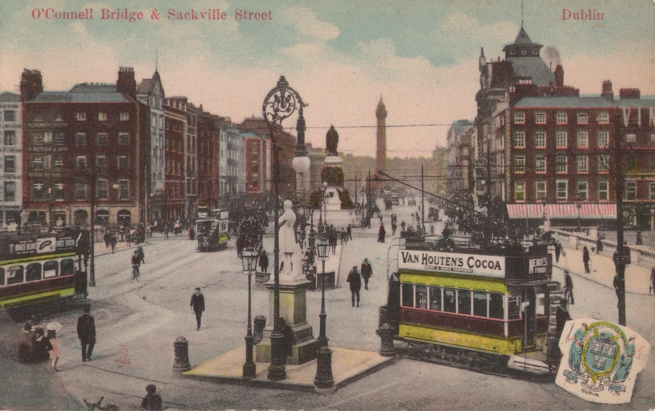 A view from around the Ballast Office back across what is now O'Connell Bridge to O'Connell St (then Sackville Street), Dublin, Ireland, showing trams with advertising, and major buildings and statues still extant