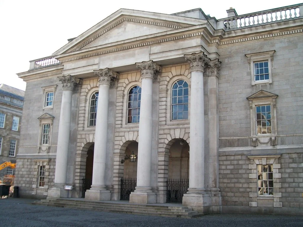 The Examinations Hall at Trinity College, Dublin This fine classical building was designed in the early 18thC by Sir William Chambers. It faces - across Parliament Square - the college chapel designed by the same architect. The Examinations Hall is also known as the Public Theatre and it possess a fine 17thC organ.