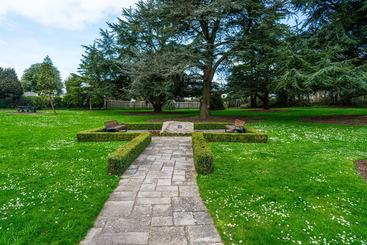 Stormont Castle. In the early years of the nineteenth century the Reverend John Cleland had, as a result of an advantageous marriage and reputedly ill-gotten gains, claimed this 215 acre demesne located in Ballymiscaw townland, 2km east-northeast of Dundonald village. In the early part of the century the estate was described as being a "house and farm" but by 1830 a new house had been built named "Storm Mount". This was described as being a "...large plain house with very little planting about it". The Gothic conservatory in the formal gardens - 964471 - is thought to date from around this time, constructed in the late 1830s. Samuel Cleland of "Storm Mount" died in an accident at the house c1842 and is buried in the churchyard of St Elizabeth's, Dundonald 791384. 
In 1858 the Cleland family began to radically alter the house. The exterior was re-designed to the fashionable Scottish Baronial style by the local architect Thomas Turner, possibly based on earlier plans by one of the leading country-house architects of the day, William Burn. Cladding of Scrabo stone was added to the plain house, with crenellations and turrets topped by fearsome gryphons. This was complemented by a terraced garden, including a complex lay-out of flower beds. A fine, and surviving, lean-to glasshouse was backed by bothies, offices and stove house. The castle's apartments included a ballroom 64 feet by 24 feet, a drawing room 36 feet by 18 feet, and other fine reception rooms, with 14 family bedrooms, besides dressing rooms and bathrooms, servants' quarters and offices. At this stage the house had assumed the name of "Stormont Castle".
By 1893 the Cleland family had deserted the castle to live abroad and it was rented out to different parties until, after the partition of Ireland in 1921, it was acquired with 235 acres of land as a site for the government buildings of the new Northern Ireland state. Shortly after this the more famous Parliament Buildings were constructed - see 693347 - some 0.5 miles to the north-west of the castle.
The house was saved from demolition by pressure of local opinion and was utilised from 1922 until 1940 as the official residence of the first Prime Minister, Sir James Craig, and subsequently as offices for the Prime Minister and the Cabinet Office. During the period of direct rule from Westminster it accommodated the office of the Secretary of State for Northern Ireland. It also served as the location of the Cabinet Room of the Government of Northern Ireland from 1921 to 1972. Under direct rule from Westminster from 1972 until devolution the castle served as the Belfast headquarters of the Secretary of State for Northern Ireland, Northern Ireland Office Ministers and supporting officials. During the "troubles" it was also used by MI5 officers.
Under devolution the castle is now used by the ministers from the Northern Ireland Executive, party officials and various civil servants. The Executive Committee meet south-western corner of the ground floor (facing here) and the First Minister's office is in an adjoining suite; the Deputy First Minister's office is directly above. The head of the Northern Ireland Civil Service has an office in the north-western corner.

Normally closed to the general public, it was accessible here during a European Heritage Open Day. Sadly, interior shots were strictly forbidden.