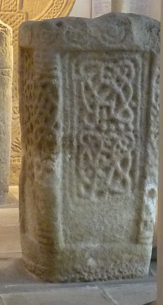 11th C cross pedestal with socket for a now absent cross. It has crude interlace pattern and moulded edging, and stood until 1968 at a farm on the River Ogmore north of Bridgend.  It is now in the Margam Stones Museum nr Port Talbot.