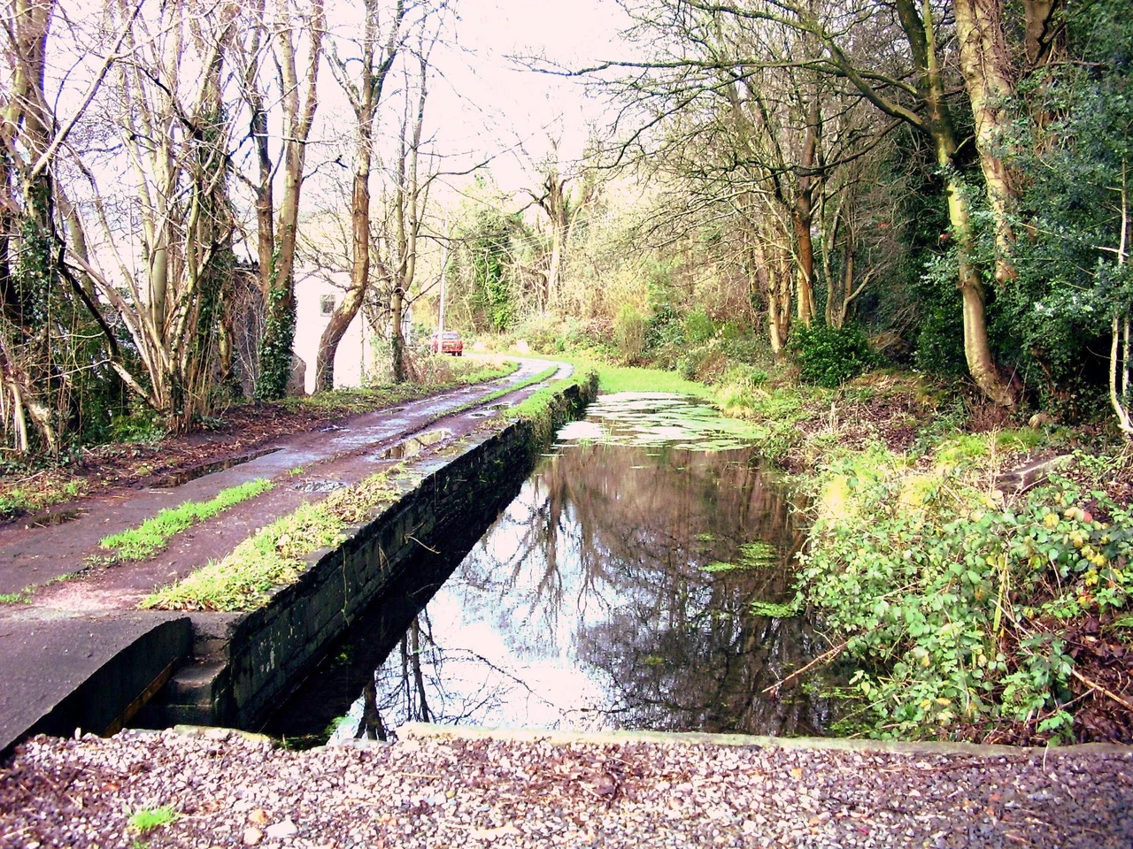 This shows the southernmost length of the remains of the Glamorganshire Canal at Pontypridd. One of the Nightingales Bush cottages can be seen. The overflow weir to the River Taff is at the lower left.