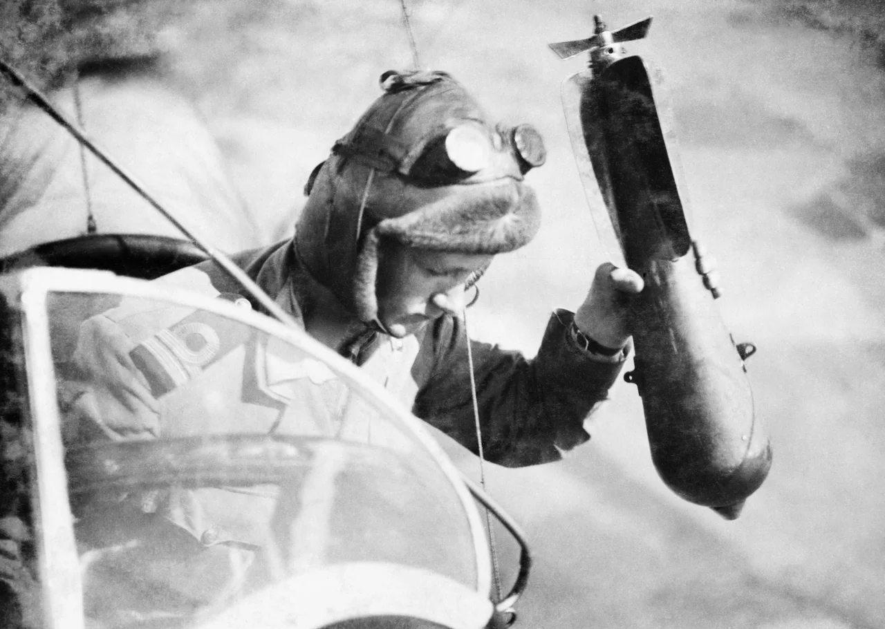 A crew member of a British SS 'Z' Class airship about to throw a bomb from the rear cockpit of the gondola.