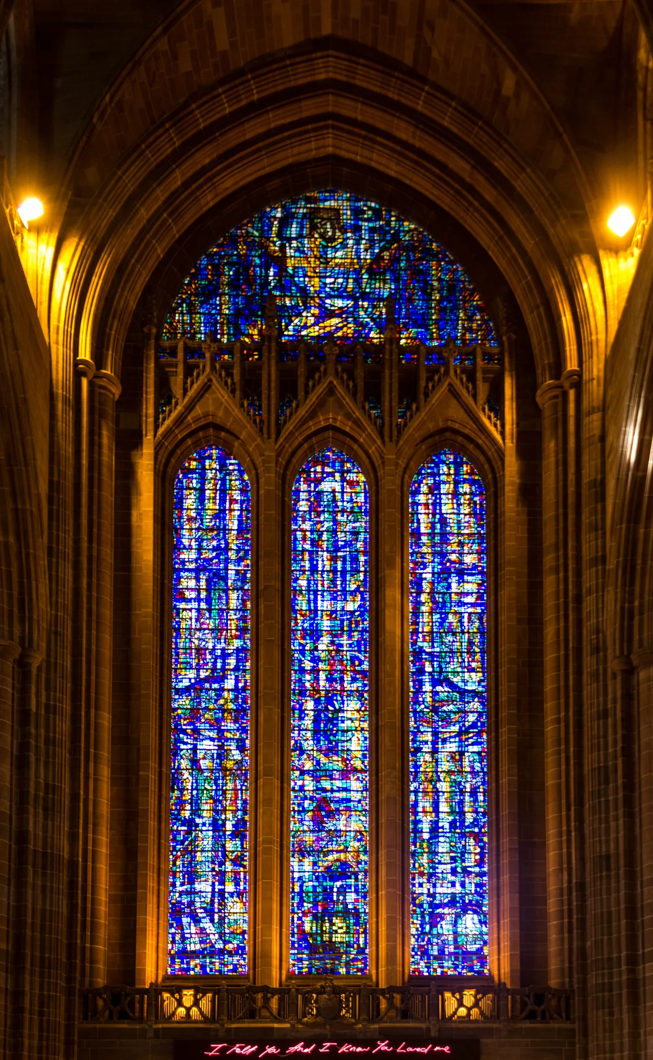 Liverpool Anglican Cathedral's stained glass west window. The uppermost window is the Bedicite window. The pink neon sign by Tracey Emin - written in the artist’s handwriting - reads "I felt you and I knew you loved me“ and was installed for the 2008 Liverpool European Capital of Culture.