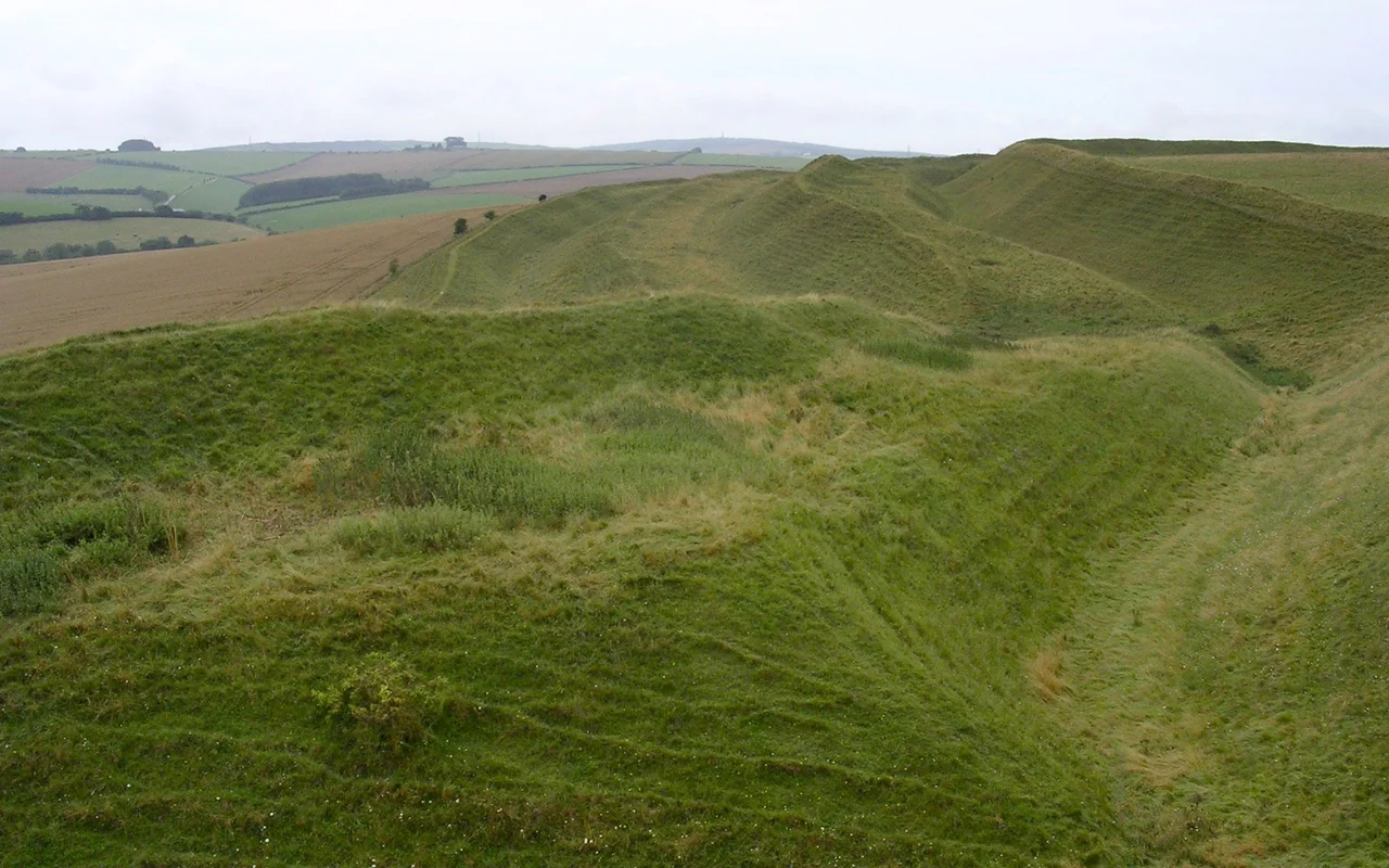 Looking west along the southern flank of Maiden Castle iron age hillfort in Dorset, towards the Hardy Monument. The ditches are not as deep as they once were, and the ramparts were once topped with wooden pallisades.