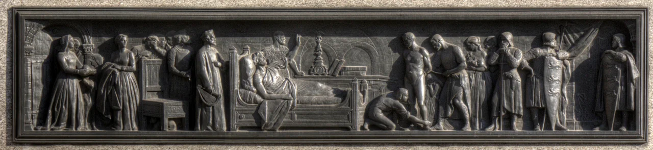 West side panel on the plinth of the statue of Richard I, Westminster, depicting King Richard I on his deathbed. Apparently ordering the liberation of a prisoner, as an act of charity to speed the transition of his soul through Purgatory.
