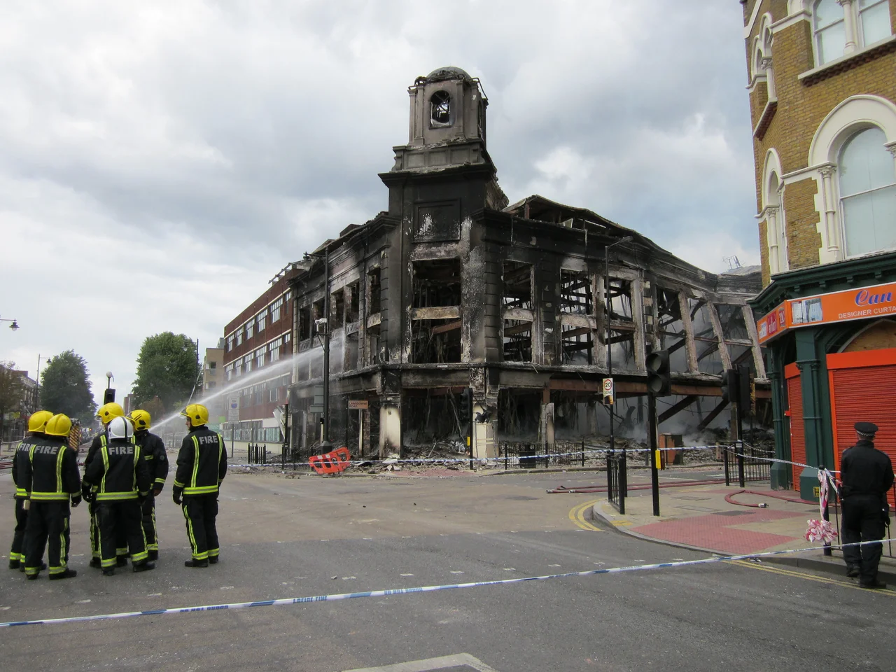 7 August 2011. 2:07 pm.
Zena and I walked to the High Road to see the dreadful damage. And spoke to some of the other residents who'd come out. 
Much of the High Road was taped off by the Police. We weren't allowed near the former Co-op and Carpet Right building which was still smouldering and looked unsafe.
______________________________________
Links
§ Click for a few seconds of video.
§ Aerial view of where this photo was taken. 
§ Liz Ixer's photo of the building only a few months before in February 2011.

§  Gareth Bedford's set of photos - 7 August.
