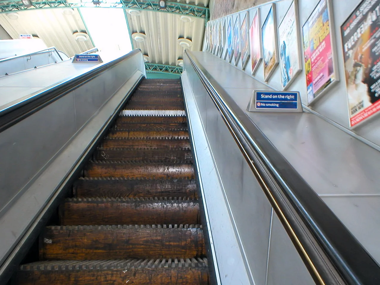 Going up the last wooden escalator on the London Underground, at Greenford station. All others were replaced in the years following the King's Cross fire in 1987. Some of the risers (The vertical part of each 'step') shown in this photo as being manufactured from wood, have since been replaced with metal ones. Note the "no smoking" sign.