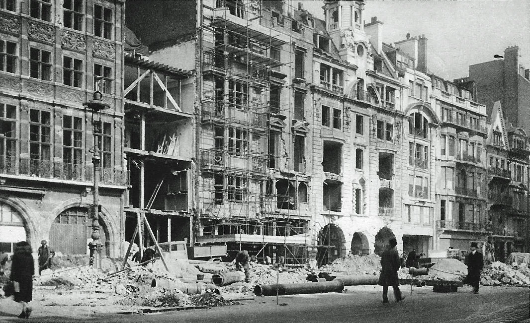 This is the west end of Pall Mall in February 1944 showing bomb damage inflicted by the German 'Operation Steinbock' which Londoners called 'The Little Blitz' or 'The Baby Blitz'. The night time bombing raids began in January and ended in April and were in retaliation for the saturation bombing of Germany. Damage was caused to The Alliance Assurance Company's building on the left which dates from 1882 and was designed by the architect of New Scotland Yard, Richard Norman Shaw. The building just along from the Alliance Assurance building is No. 61 Pall Mall which since 1897 had been the premises of the Hardy's fishing tackle shop. The photographer is standing with his back to St. James's Palace.