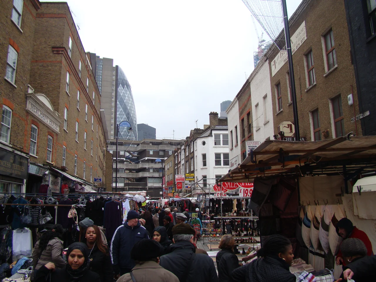 View of the Gherkin and buildings on Middlesex Street from Petticoat Lane Market. This is the view in the opposite direction to 1703445, taking looking south-southwest from Wentworth Street, showing the blocks of flats on Middlesex Street and the Gherkin towering above those.