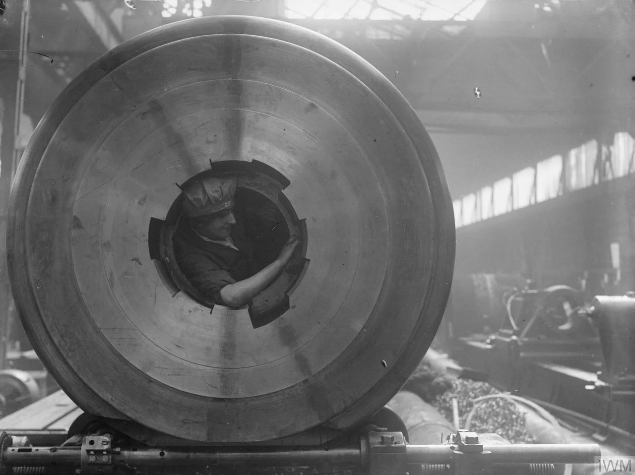 IWM caption : "A female worker cleans the rifling of a 15-inch gun after being lifted inside the barrel in the Coventry Ordnance Works during the First World War".