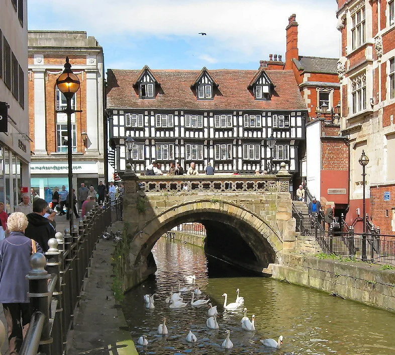 The High Bridge on Lincoln High Street dates from 16th century and carries the road, once one of the two main routes through the centre of Lincoln, over the River Witham. The area is now pedestrianised. The bridge is the only one in Britain still in use today with a secular a medieval building still standing on it and incorporated in its structure are the stone ribs of what is believed to be the second oldest masonry arch bridge in the country. Built of stone with later brickwork, the bridge has been extended in various stages - including an extension to accommodate a chapel in 1235 and a range of timber buildings in 1540-50. The original timber frame house was stripped down to the bare timbers in 1901-2 and completely restored to what is seen here.