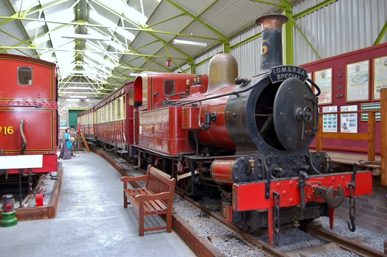 Isle of Man Railway steam locomotives on static display at the Port Erin Railway Museum, Port Erin, Isle of Man: (L-R) No. 16 Mannin, No. 6 Peveril with a train of coaches.