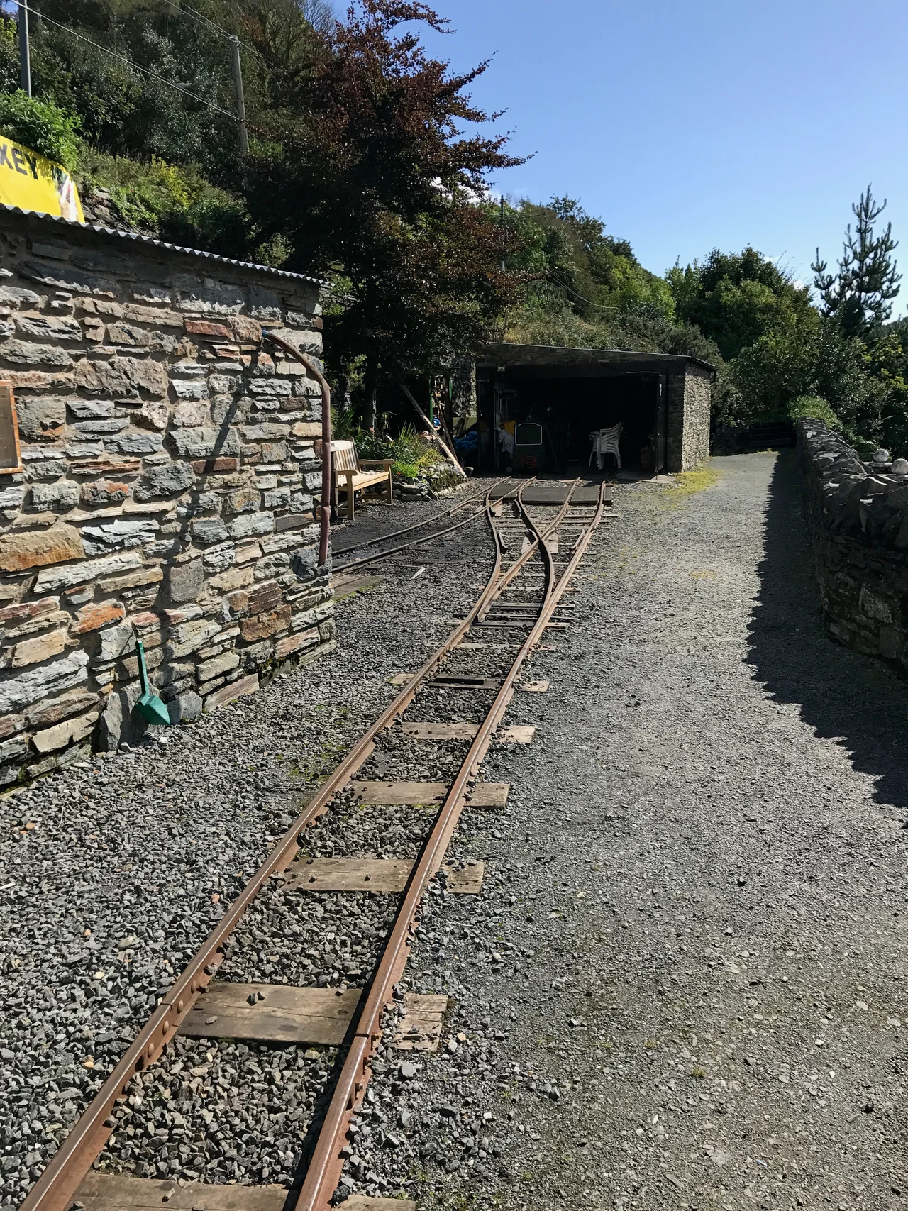 The engine and carriage sheds at Valley Gardens on the Great Laxey Mine Railway, Isle of Man. Locomotive 'Wasp' is visible, undergoing maintenance.