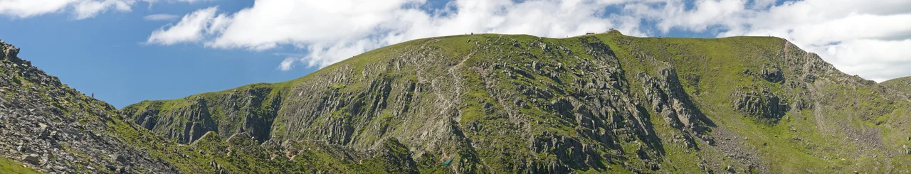 A panoramic view of the ascent of Helvellyn with Striding Edge on the left, then a steep scramble to the summit followed by a scrambling descent via Swirral Edge on the right, leading to Catstye Cam.