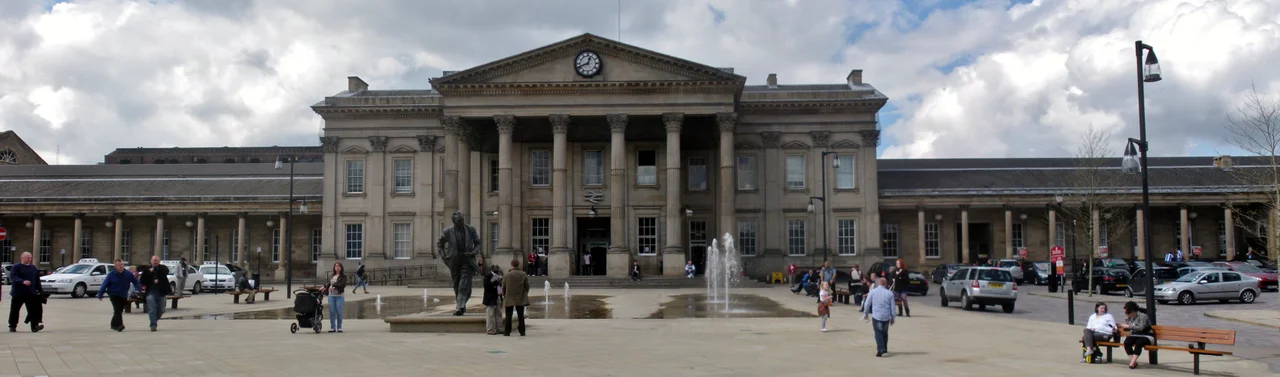 Huddersfield railway station in St Georges Square, A bronze statue of the late former Prime Minister of the United Kingdom Harold Wilson stands in the square before it. Wilson originated from the town.