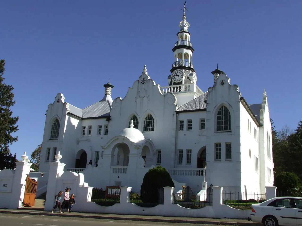 Local Tourism authority states in its blog on this building:

“There are also several interesting buildings dating from the beginning of the 20th century, the most noteworthy being the Dutch Reformed ‘Moederkerk’ with its eclectic architectural features, including Gothic, Renaissance, Baroque and vernacular Cape elements”

This media shows a South African Protected Site with SAHRA file reference 9/2/092/0029.