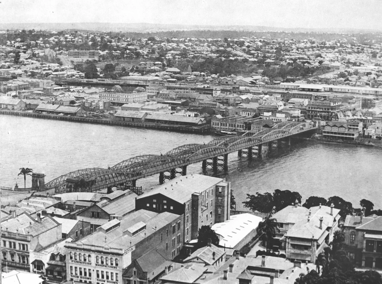 Elevated view of the second permanent Victoria Bridge spanning the Brisbane River, ca. 1933.
This bridge was officially opened on 1st October 1896. The first permanent bridge was washed away in floods in 1893. View is from the clock tower on Town Hall, looking south.