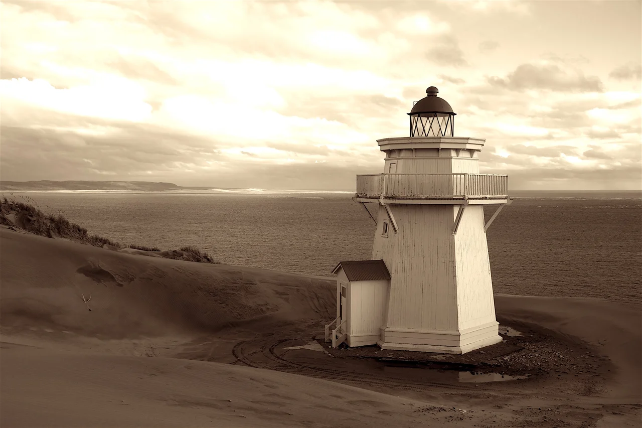 The Kaipara North Head Lighthouse was built in 1884 in response to the continued loss of ships and lives.
13.4 m wooden tower. Last wooden tower built in New Zealand.
The settlement grew in response to employment opportunities but by 1920 steamers had largely replaced sailing ships, and the large sawmills had closed as the kauri forests were exhausted. In 1947 the Kaipara Harbour was closed as a port of entry to New Zealand. In 1952 the light was dismantled and the lighthouse decommissioned. The associated houses were barged to various locations around the Kaipara.
Restoration and maintenance of the lighthouse is now being undertaken by the Historic Places Trust.