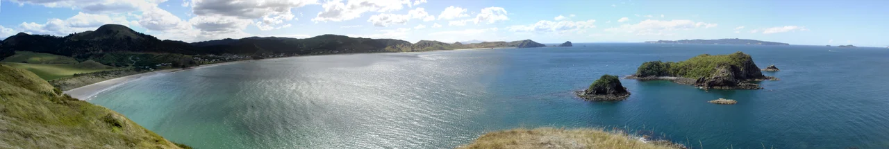Panorama of Opito Bay on the Coromandel Peninsula, New Zealand.  Rabbit Island in the foreground on the right, with Great Mercury Island visible on the horizon