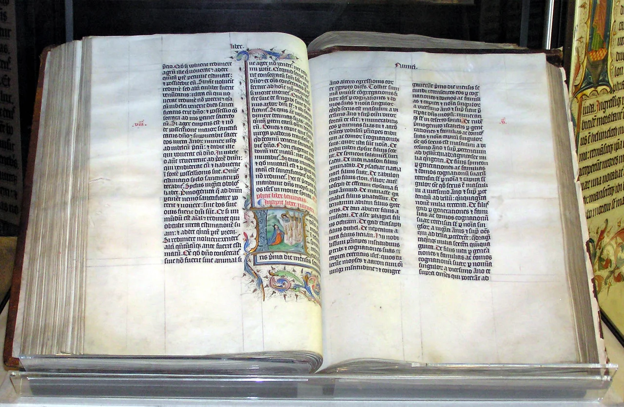 A Bible handwritten in Latin, on display in Malmesbury Abbey, Wiltshire, England. This Bible was written in Belgium in 1407 AD, for reading aloud in a monastery.