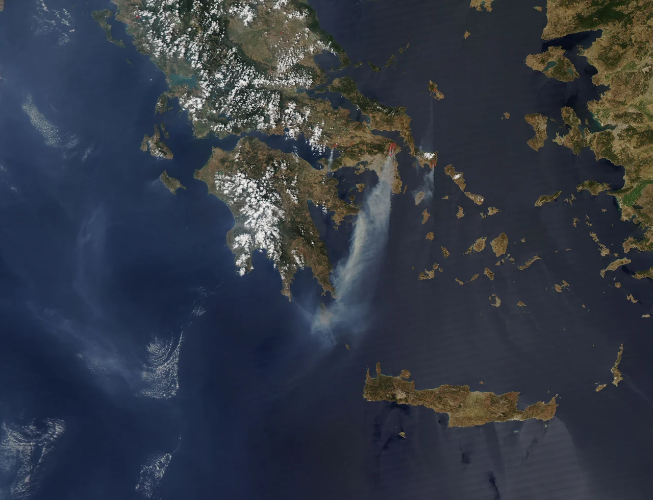 Flames raced through the forests northeast of Athens, Greece, on August 22, 2009, when the Moderate Resolution Imaging Spectroradiometer (MODIS) on NASA’s Aqua satellite captured this image. Areas where the sensor detected fire on the ground are outlined in red. The fire outside Athens started on Friday, August 21, north of the famed Marathon plain. Aided by strong winds, the fire quickly grew, reaching the edge of Athens, said the Associated Press. The wind also blew thick plumes of smoke from the fire over the city. The smoke plume extends more than a hundred kilometers over the Aegean Sea in this image. As of August 24, six major wildfires burned in Greece, consuming more than 15,000 hectares of forest and brush, reported the Associated Press. On the afternoon of August 22, MODIS detected five of the fires. The fires destroyed homes and forced evacuations, but caused no serious injuries to date, said the Associated Press. Hot, dry summers make Greece prone to fire. In 2007, massive fires on the Peloponnesus Peninsula killed 76 people and burned vast tracts of forest. The large image provided above is at MODIS’ maximum resolution of 250 meters per pixel. The image is available in additional resolutions from the MODIS Rapid Response System.
NASA image courtesy Jeff Schmaltz, MODIS Rapid Response at NASA GSFC. Caption by Holli Riebeek. Instrument:  Aqua - MODIS