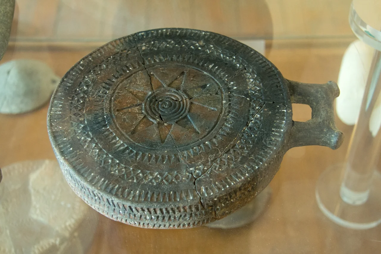 Especially nice Clay Cycladic "frying-pan" with the spiral and nine-numerous stars. The scratches are filled with white kaolin. "Non feminine" type. Found in cemetery at Kato Mili on the island of Pano Koufonisi (Small Cyclades, Mikres Kyklades). Early cycladic II period, 2800-2500 BC. Archaeological Museum of Naxos.