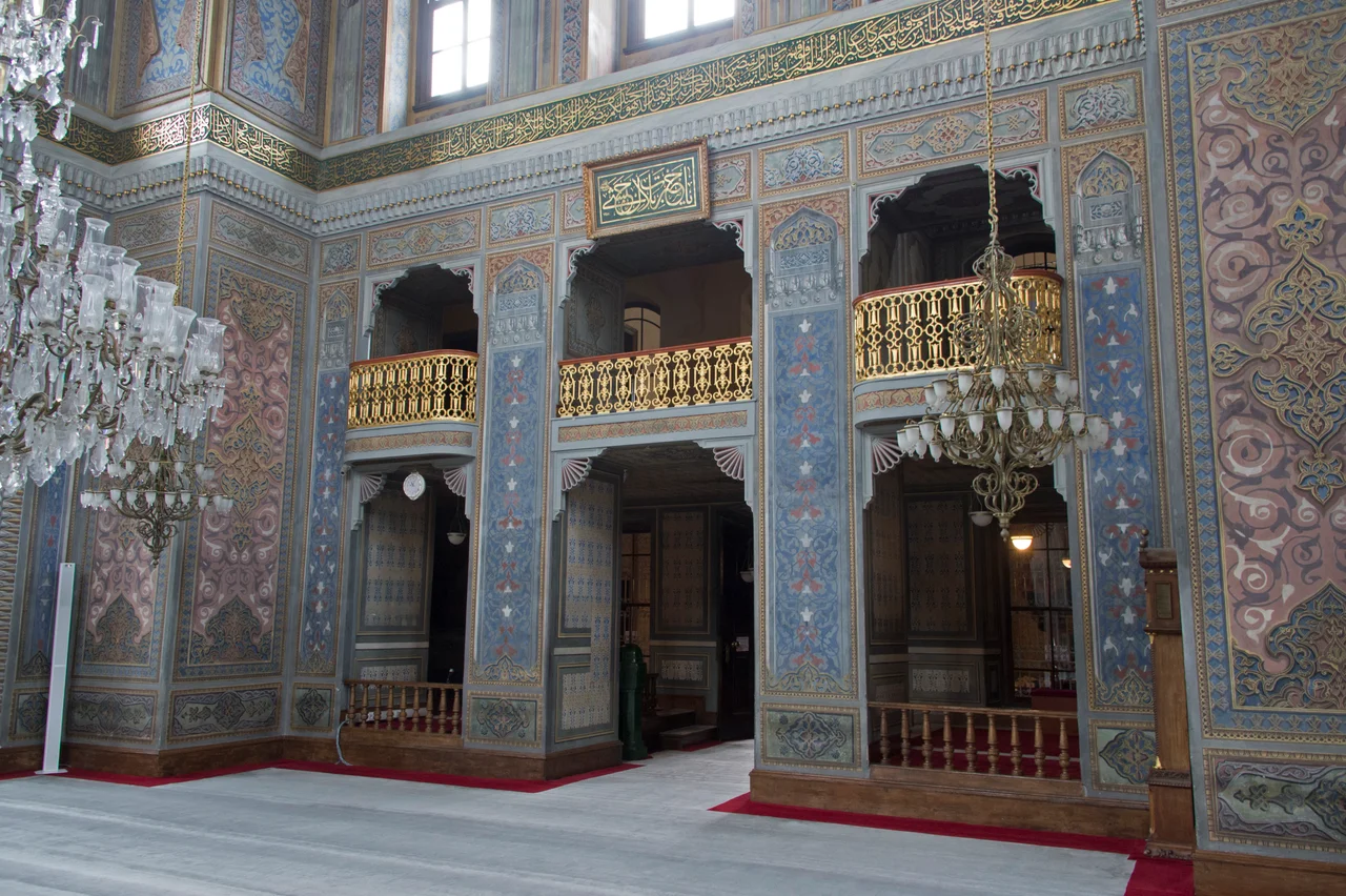 Strolling through Istanbul, is harsh on this mosque: "It combines elements from Moorish and Turkish, Gothic, Renaissance and Empire styles in a garish rococo hodgepodge". The mosque was built in 1871 for the mother of Sultan Abdül Aziz. It seems to be by the Armenian architects Hagop and Sarkis Balyan, who built some of the late Ottoman palaces along the Bosporus. The complex is an oasis of quiet near Aksaray, one of the busiest points in town.