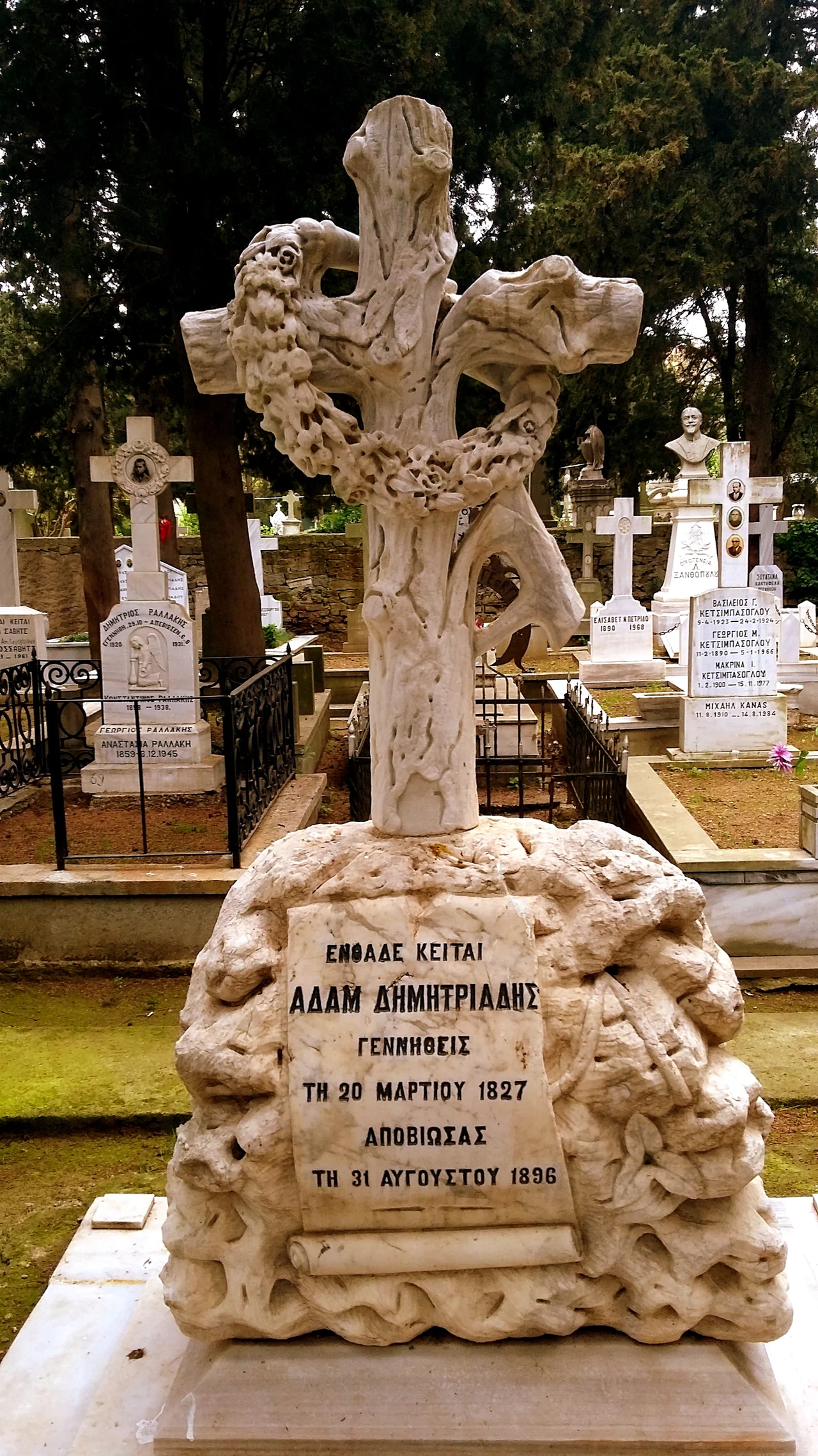 Ornately carved stone cross with wreath tomb in St. Ignatius Cemetery