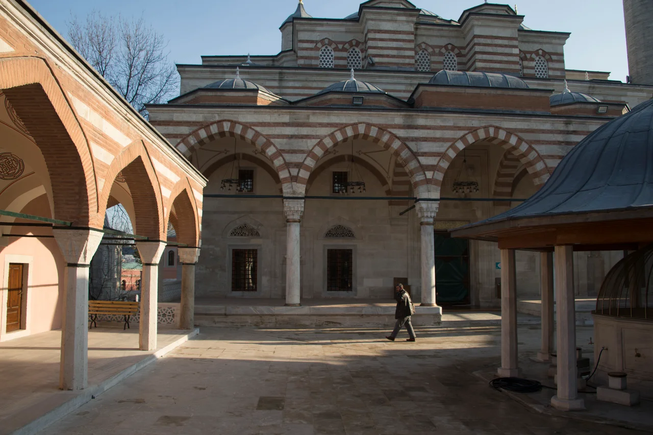 The Strolling through Istanbul guide has it the Zal Mahmut Paşa mosque is the "grandest and most interesting mosque in Eyüp, a mature but unique work of Sinan." Zal "was a rather unsavoury character, when in 1553 Süleyman had his son Mustafa put to death, it was Mahmut (who got his forename Zal from that of a Persian hero famous for his Herculean strength) who overcame the young prince’s resistance and strangled him. Later he married the Princess Şah Sultan, sister of Selim the Sot, as a reward, it is said for having smoothed that prince’s path to the throne by the elimination of his brother. In 1580 Zal and his wife died in a single night.
The külliye has an awkard form because of the available grounds. They slope, so under the mosque there is a vaulted substructure, containing rooms for a lower medrese (there are two medreses, on the picture a side of the higher one). In the lower grounds there is a mausoleum for the founder.