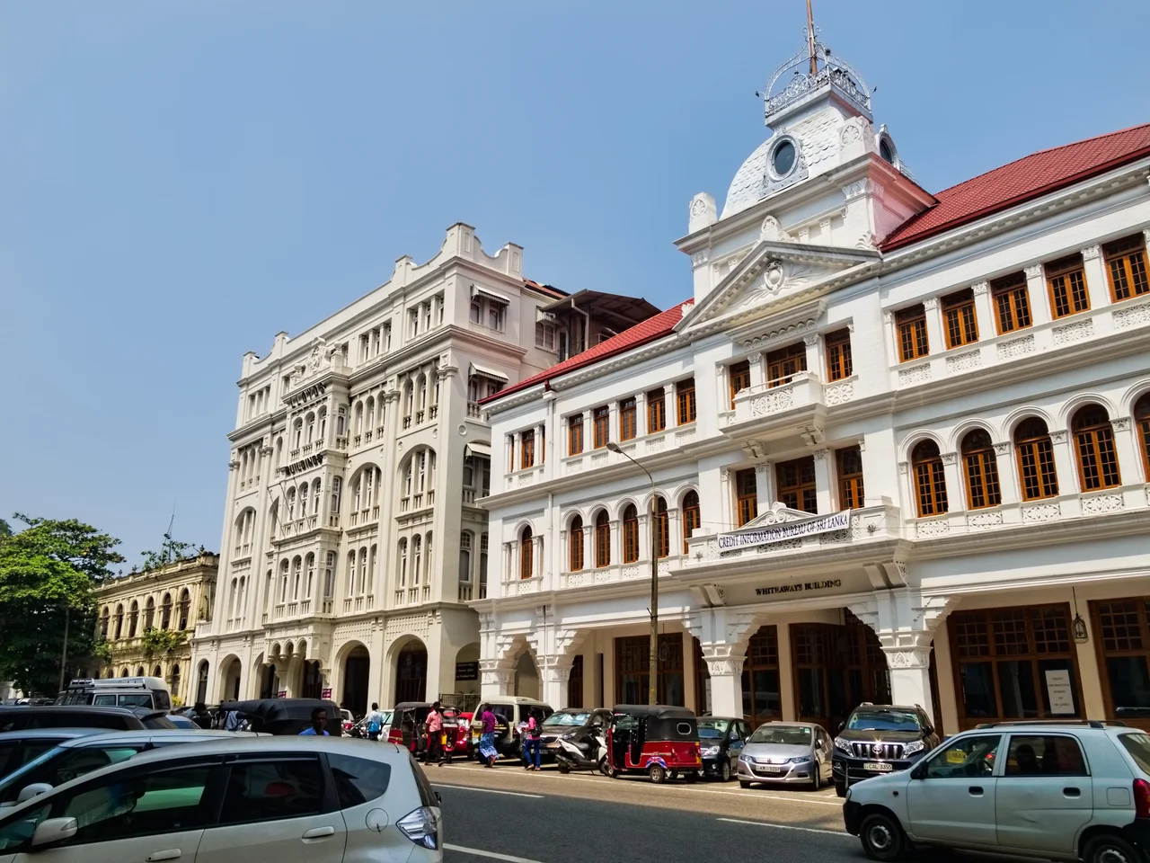 Restored colonial-era buildings in Fort.  The covered, colonnaded sidewalk was typical of colonial architecture to provide protection from sun and monsoons.
Fort, where in the 1870s the British built a fort now gone, is the center of Colombo and is seeing a resurgence after the bombing of the Central Bank in 1996 during the civil war with the Tamil Tigers prompted businesses to disperse to outlying neighborhoods.  The government has realized that restoring heritage buildings rather than replacing them with modern high-rises will create an area more attractive to locals and tourists alike.
On Google Earth:

Fort  6°56'10.83"N, 79°50'39.44"E