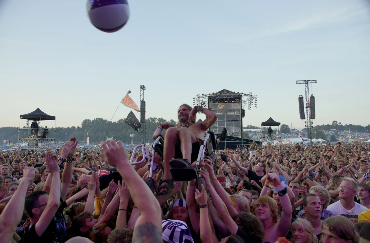 Przystanek Woodstock Festival 2012, Poland - a wheelchaired man being crowdsurfed at a concert
