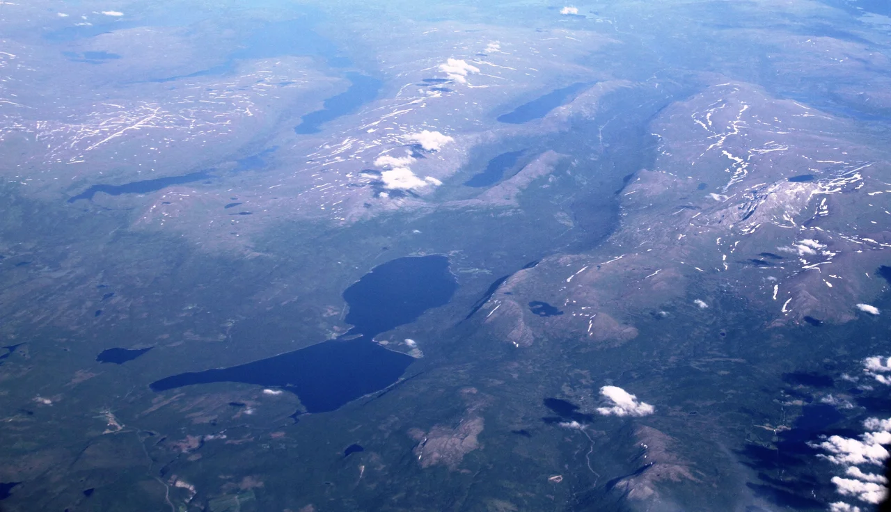 Aerial view from the west towards east, over eastern Hattfjelldal municipality and Sweden in the distant back.