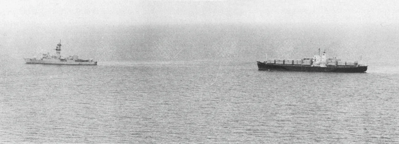 The U.S. Navy ocean escort USS Harold E. Holt (DE-1074) tows the SS Mayaguez away from Koh Tang island, Cambodia, on 15 May 1975, during the Mayaguez incident.
